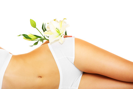 A picture of a slim female belly and a flower over white background